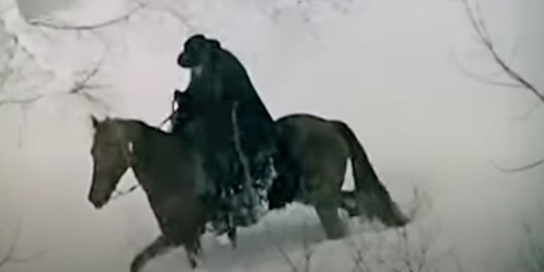 A man riding a horse in the opening sequence in the Great Silence