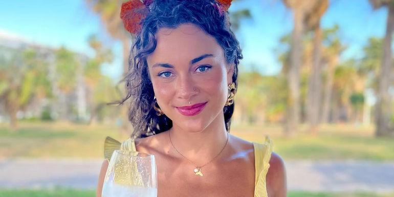 Below Deck Marie Marquis Instagram Post where she is closed-mouth smiling while holding a wine glass - Sunny Marquis's Before Below Deck