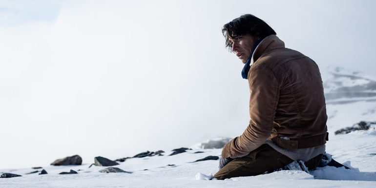 Enzo Vogrincic kneeling in the snow in Society of the Snow