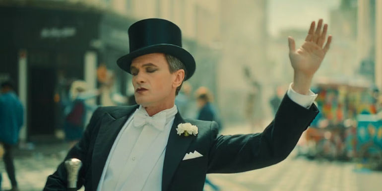 The Toymaker dances through the street wearing a tuxedo with a top hat in Doctor Who.