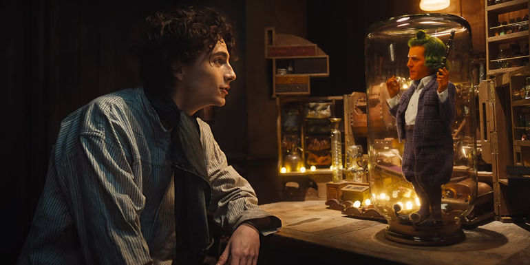 Timothee Chalamet talking to Hugh Grant as an Oompa-Loompa in Wonka