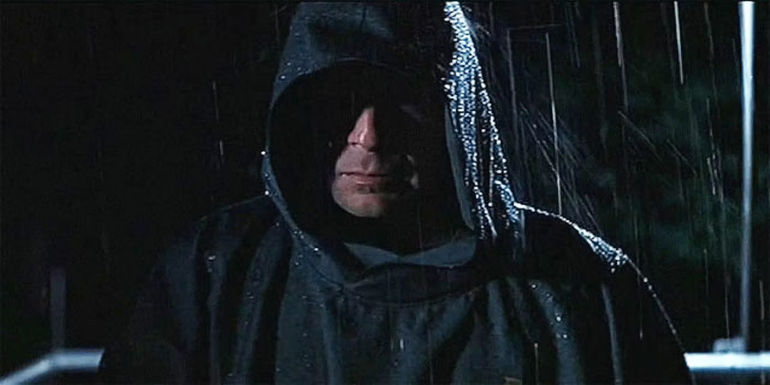 Bruce Willis as David Dunn in a raincoat in Unbreakable.