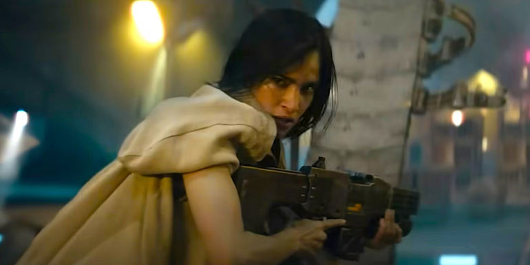  Sofia Boutella's Kora aiming her gun and looking over her shoulder in Rebel Moon Part One A Child of Fire