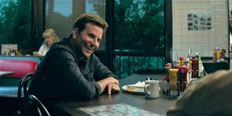 Bradley Cooper as Agent Colin Bates sitting at a table in a diner in The Mule