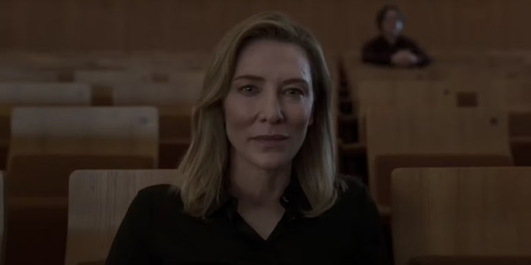 Lydia Tar (Cate Blanchett) sitting at the audience seats in the theater in Tar