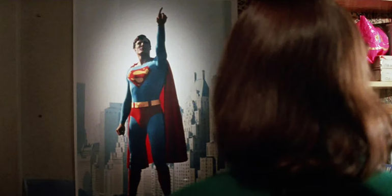 Supergirl, looking at a Superman poster in Supergirl (1984)