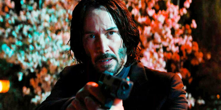 Keanu Reeves as John Wick holding a gun in John Wick: Chapter 4.