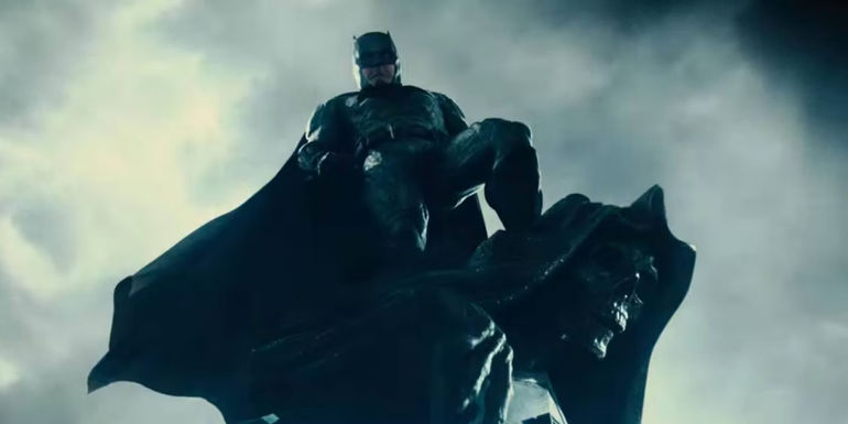 Ben Affleck as Batman in Zack Snyder's Justice League, standing on top of a gargoyle and looking down.