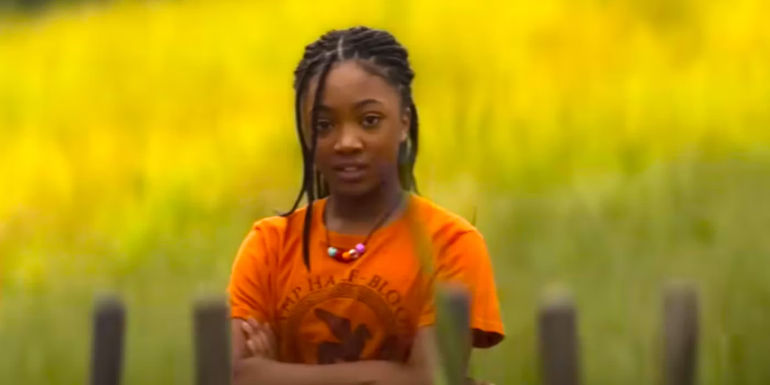 Leah Jeffries as Annabeth Chase wearing an orange Camp Half-Blood shirt and crossing her arms in Percy Jackson and the Olympians
