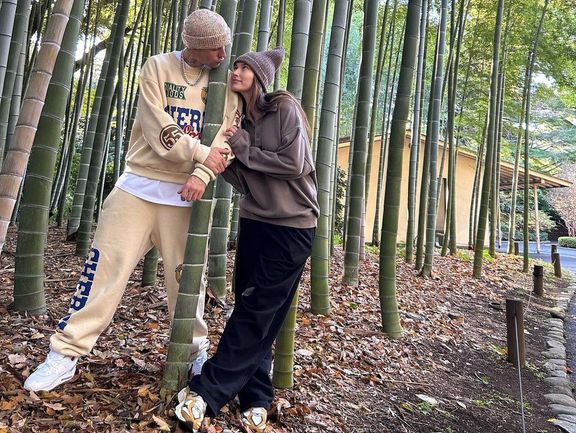 Justin Bieber embracing a woman in a bamboo forest.