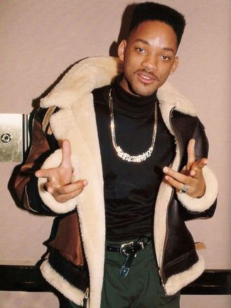 Will Smith posing in a fur-lined coat, black turtleneck, gold chain, and dark pants.
