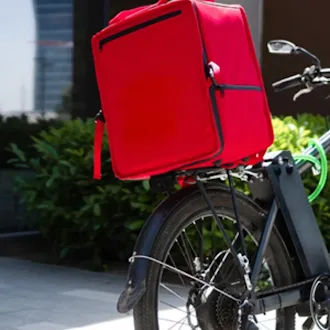 Bicycle courier with red delivery box for local delivery service