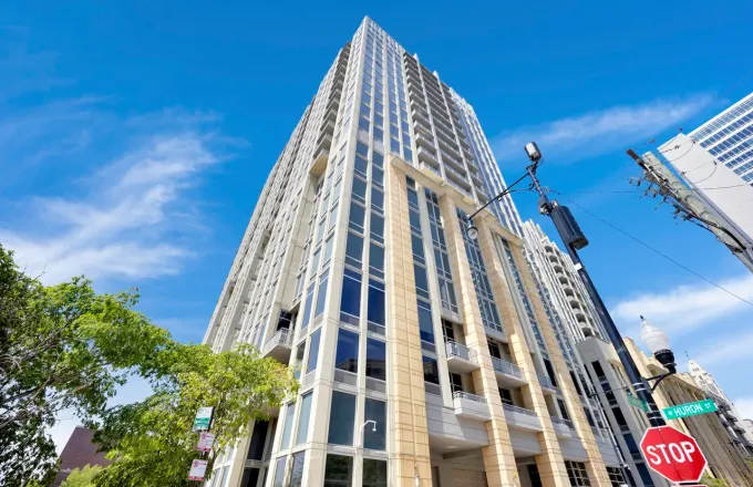 700 N Larrabee St River North condo two-bathroom full remodel by Assembly Squad -- primary bath full teardown with new tub and double vanity, second bath shower rebuild with custom-poured concrete base and Schluter RedGard waterproofing, frameless glass shower door in Chicago
