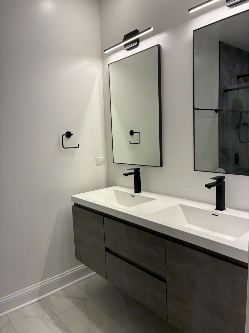 After -- floating concrete-gray double vanity with black fixtures and LED mirrors at 456 W Briar Pl