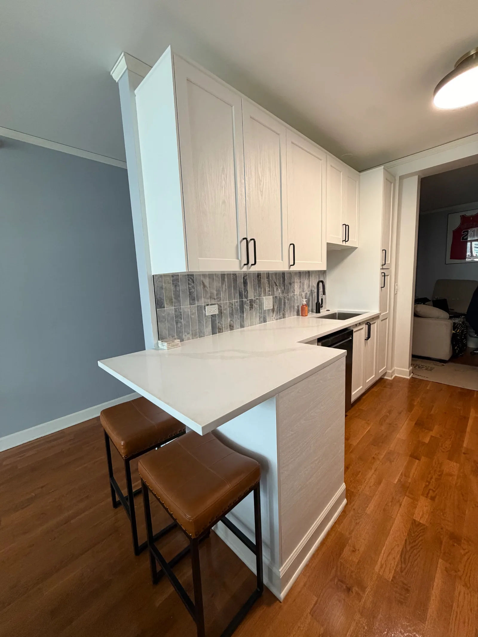 After -- new breakfast bar with extended quartz overhang and two bar stools at 450 E Waterside Dr, The Chandler, Lakeshore East, by Assembly Squad