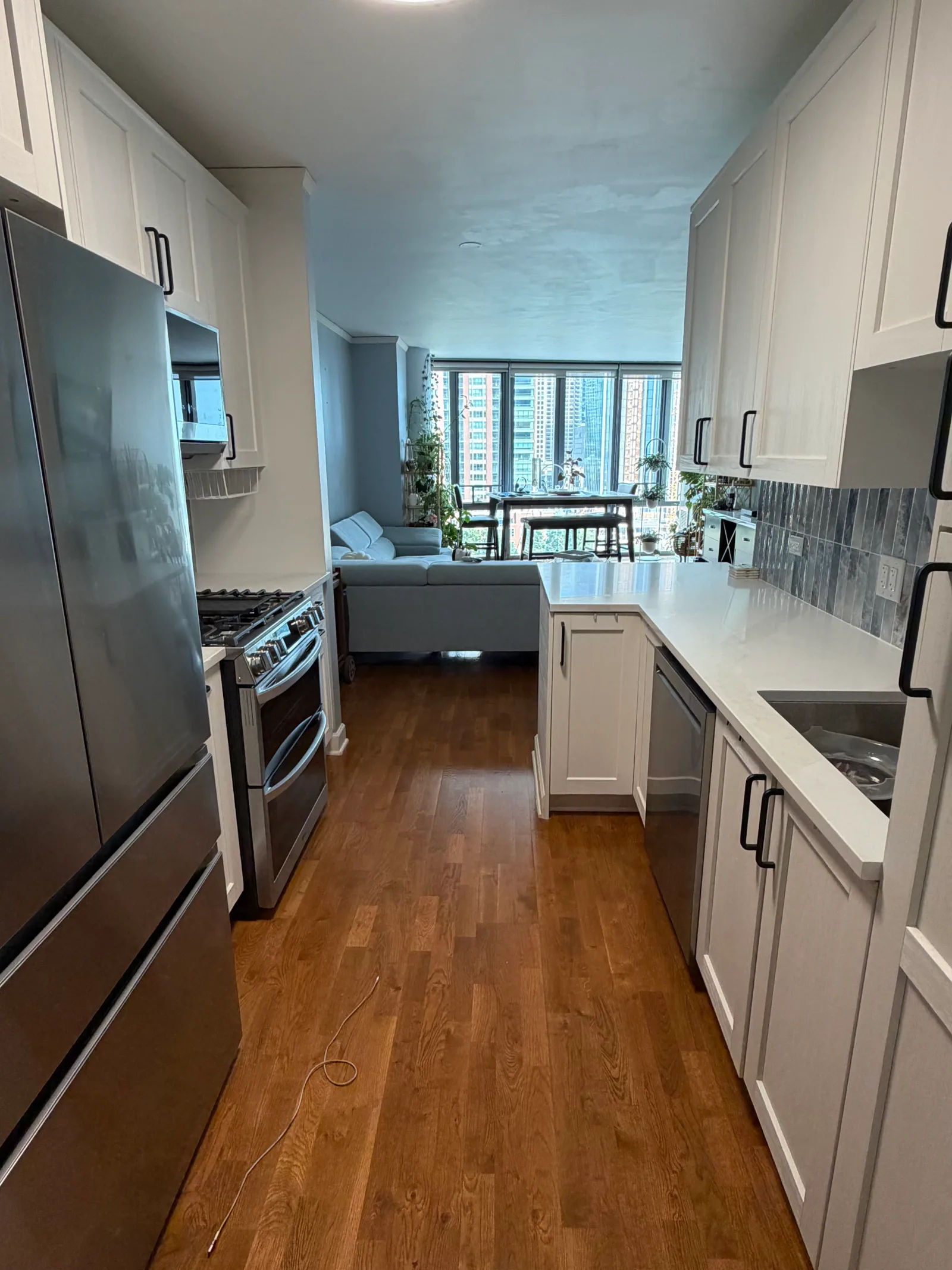 After -- completed galley kitchen opening to the living room at 450 E Waterside Dr, Unit 510, The Chandler, Lakeshore East, by Assembly Squad