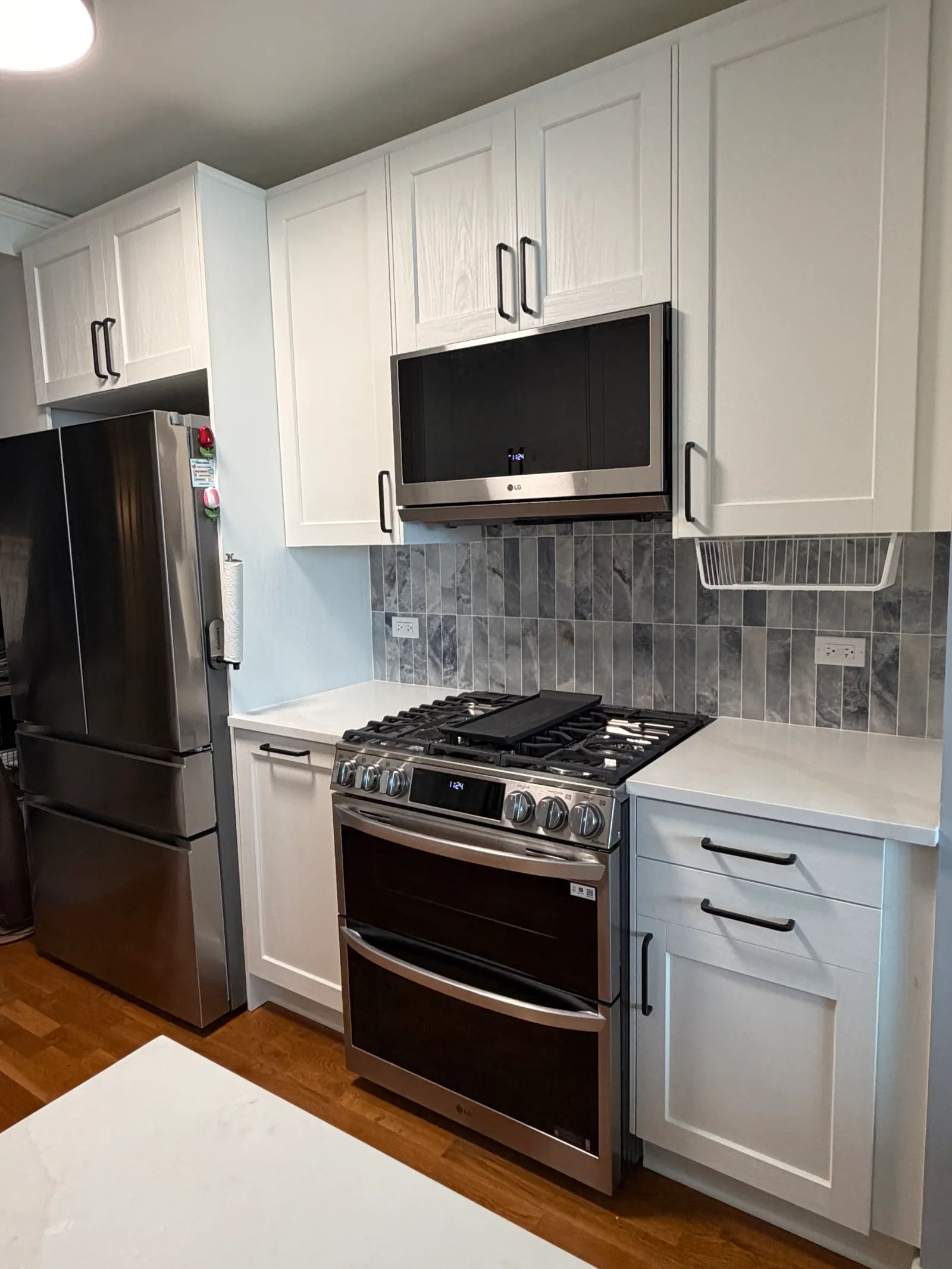 After -- completed kitchen remodel with white shaker IKEA cabinets, MSI quartz countertops and marble-look backsplash at 450 E Waterside Dr, The Chandler, Lakeshore East, by Assembly Squad
