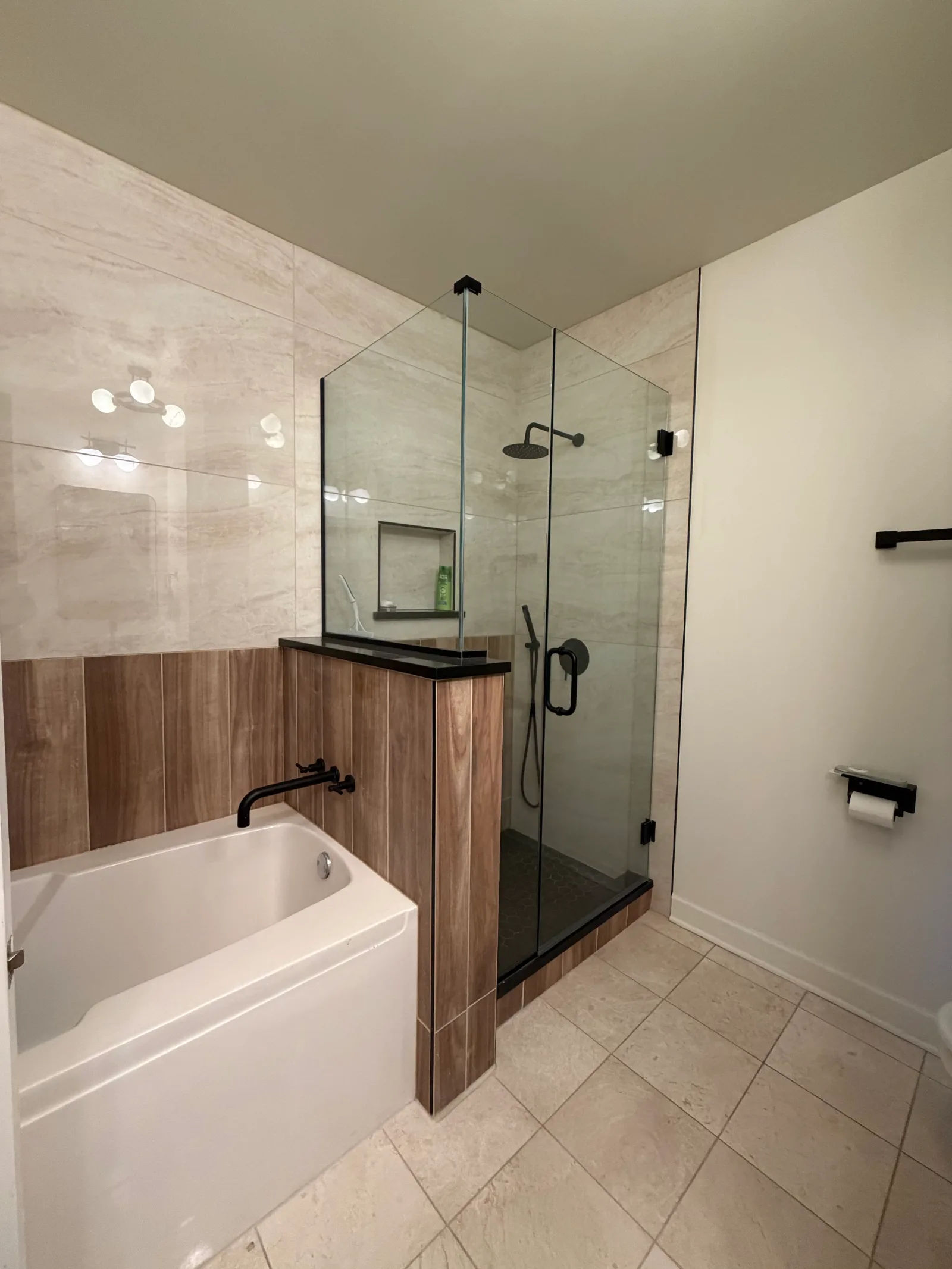 After -- tub beside the new frameless glass walk-in shower with redesigned tiled knee wall at 450 E Waterside Dr, Unit 510, The Chandler, by Assembly Squad
