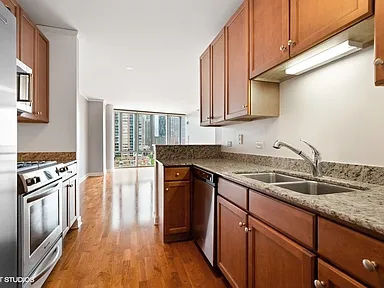 Before -- original 2007 builder-grade kitchen with oak cabinets and granite countertops at 450 E Waterside Dr, Unit 510, The Chandler, Lakeshore East, prior to the Assembly Squad renovation