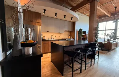 South Loop loft kitchen renovation at 1632 S Indiana -- open plan with custom cabinetry, exposed ceilings, and black island