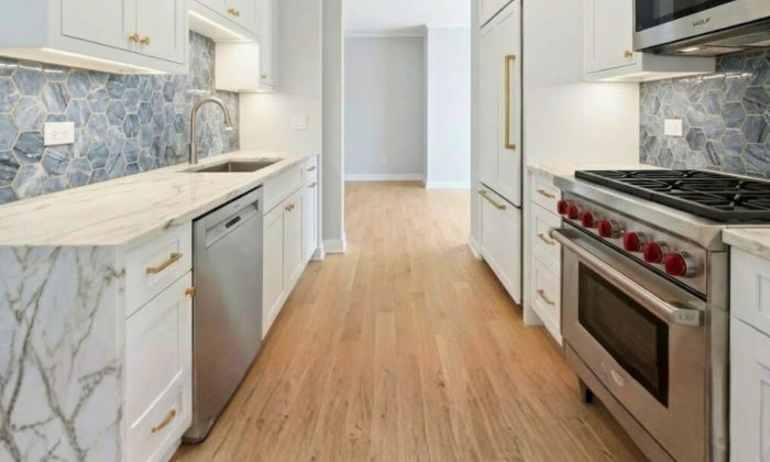 After small kitchen remodel The Chandler Condominiums Chicago -- custom floor-to-ceiling cabinetry under-cabinet LED lighting zellige backsplash Wolf range Assembly Squad