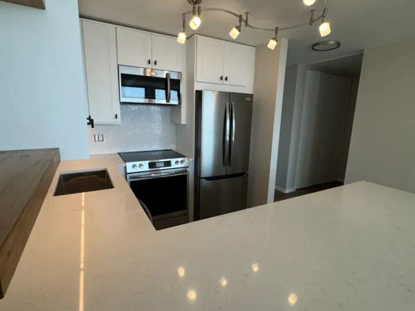 111 E Chestnut Streeterville open-concept kitchen after remodel -- wall removed, quartz countertops, Chicago 60611