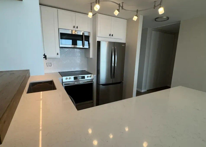 111 E Chestnut Streeterville open concept kitchen after remodel -- wall removed quartz countertops modern design Chicago 60611