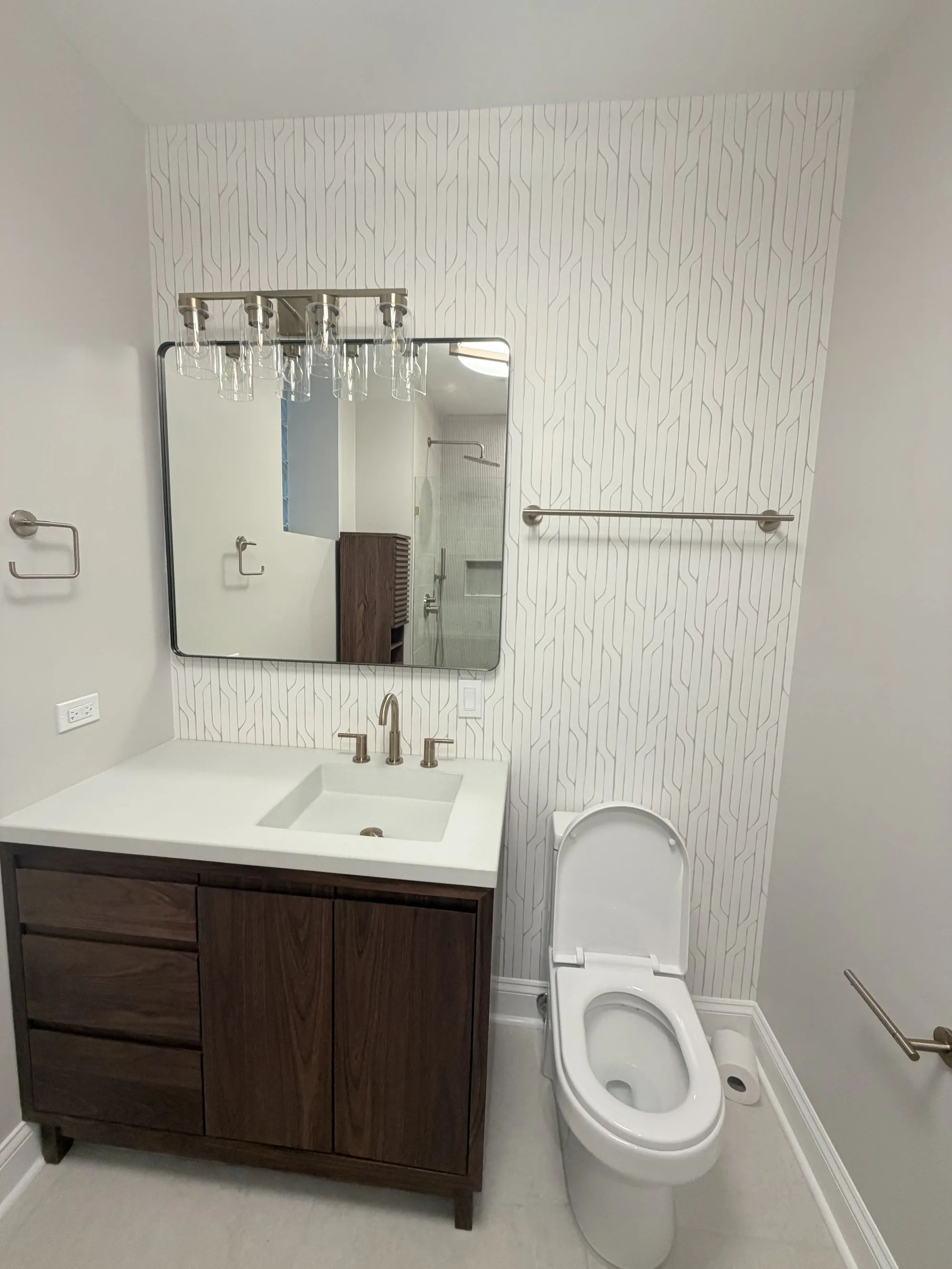 After -- bathroom with a walnut vanity, quartz top, and geometric wallpaper at 3054 N Sheffield Ave, Lakeview