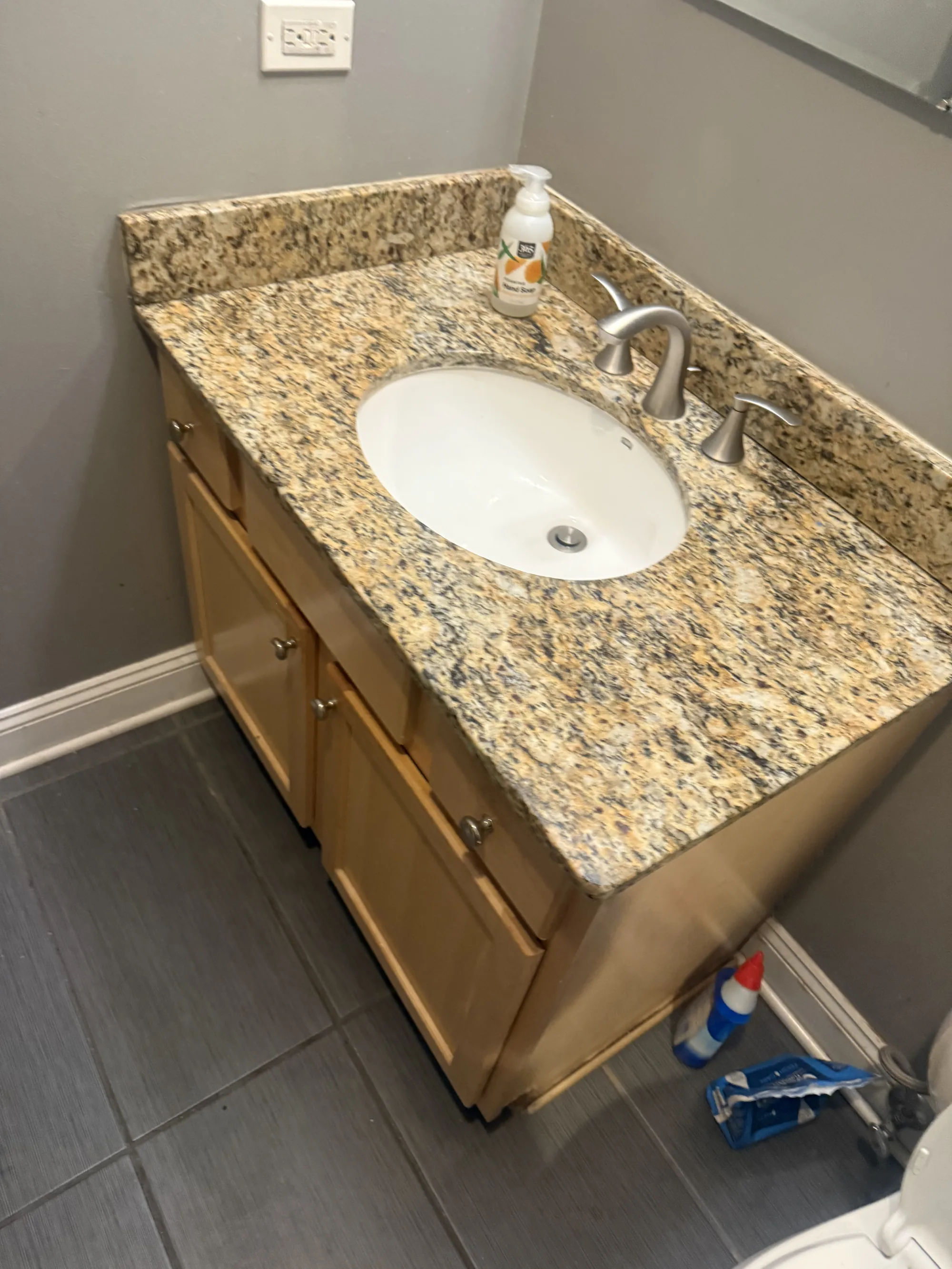 Before -- original bathroom vanity with granite top and maple cabinet at 3054 N Sheffield Ave, Lakeview, before renovation