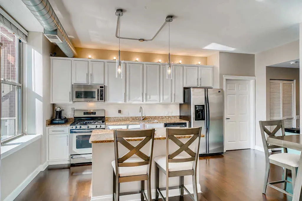 West Loop condo open concept kitchen with walnut flooring and island