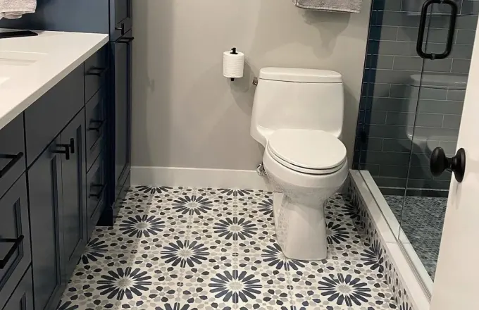 N Sheffield Ave Lincoln Park 60614 bathroom gut renovation by Assembly Squad -- custom blue-gray vanity cabinets, white quartz countertop, Kohler fixtures, decorative cement pattern floor tile, dark subway tile walk-in shower with frameless glass, matte black hardware in Chicago