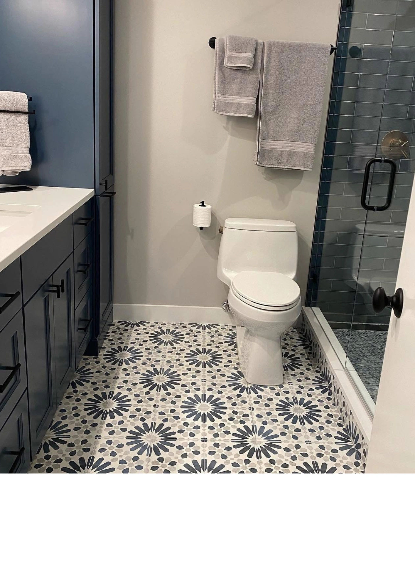 Finished bathroom on N Sheffield Avenue -- blue-gray shaker vanity, white quartz countertop, patterned cement tile floor
