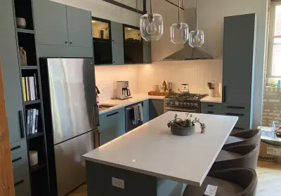 Uptown loft kitchen renovation at 3900 N Claremont with European-style light green custom cabinetry and quartz countertops
