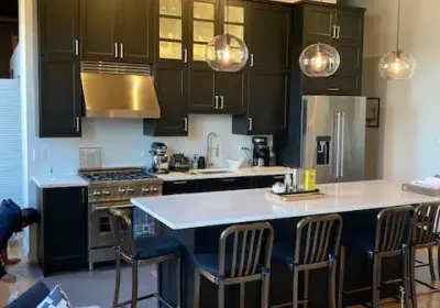 Modern black IKEA kitchen renovation in West Loop loft featuring sleek cabinetry, quartz countertops, and stainless steel appliances completed in 2 weeks