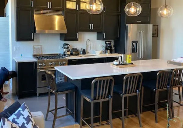 West Loop loft kitchen remodel -- bold black cabinets and quartz countertops by Assembly Squad