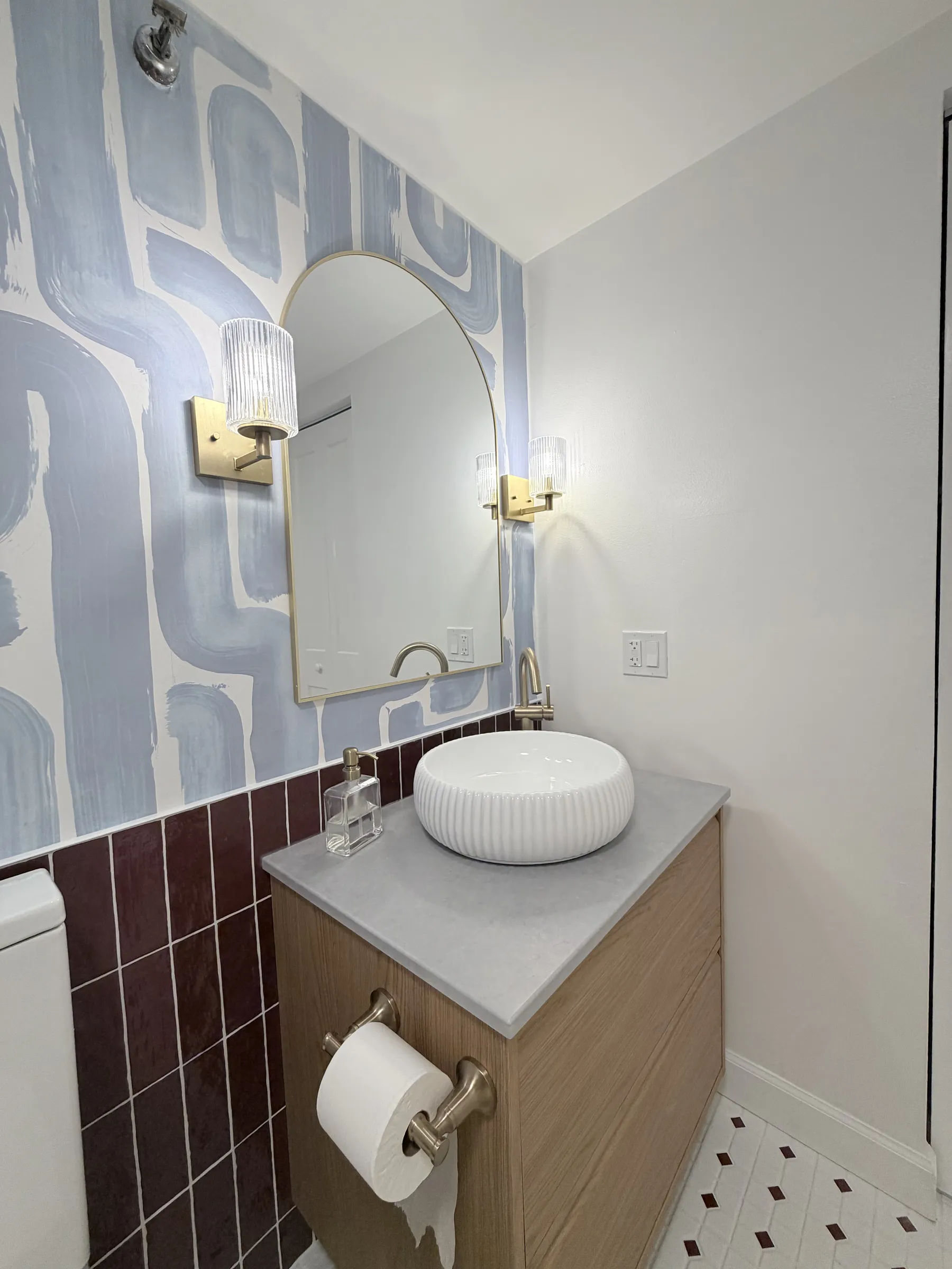 After -- wall-hung oak vanity with fluted vessel sink, gold-framed mirror and satin-bronze fluted sconces at 124 W Polk, The Lex, Printers Row, by Assembly Squad