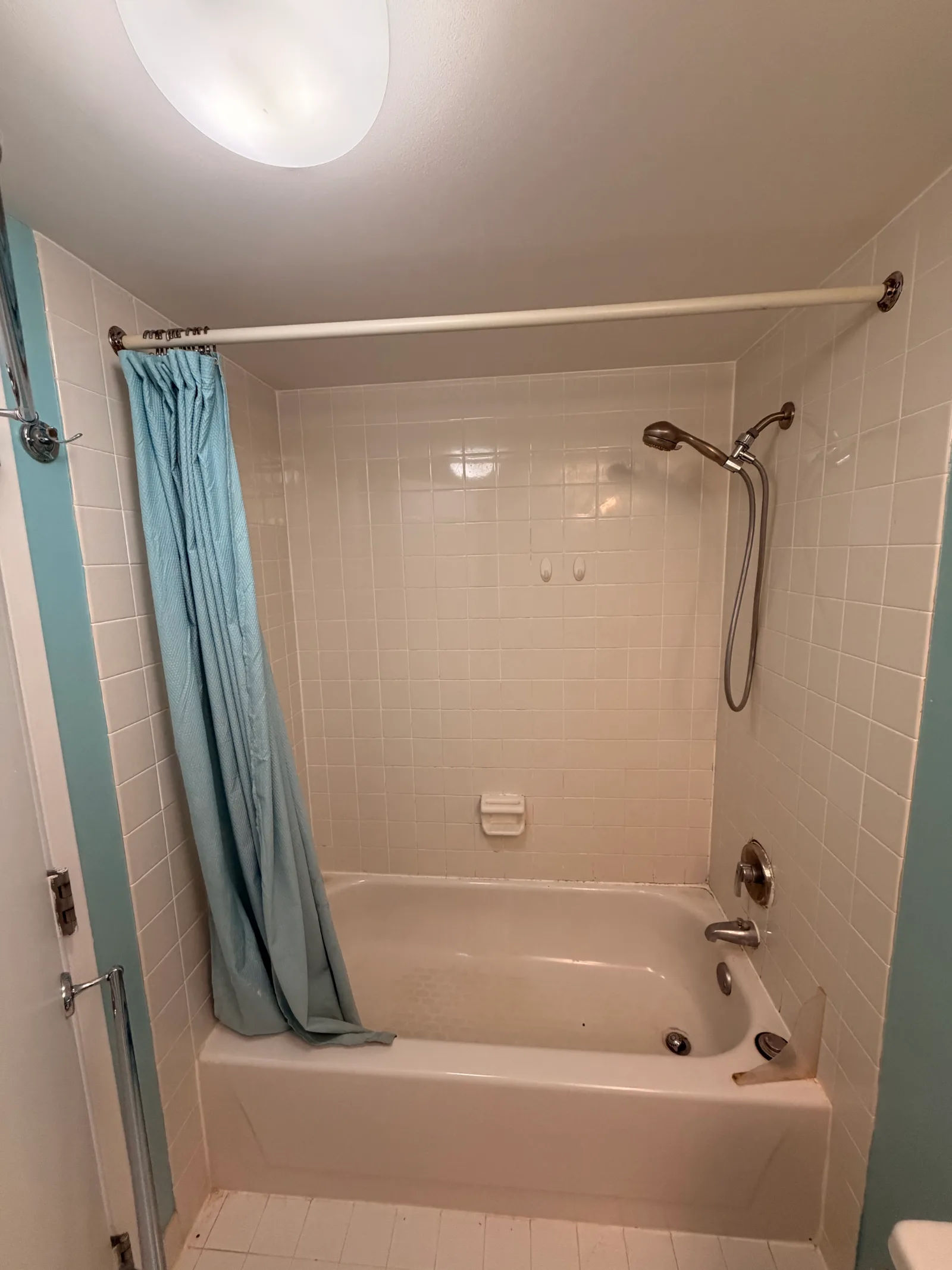 Before -- original bathroom with alcove tub, white 4x4 ceramic tile and tension-rod shower curtain at 124 W Polk, Unit 707, The Lex, Printers Row, prior to the Assembly Squad remodel