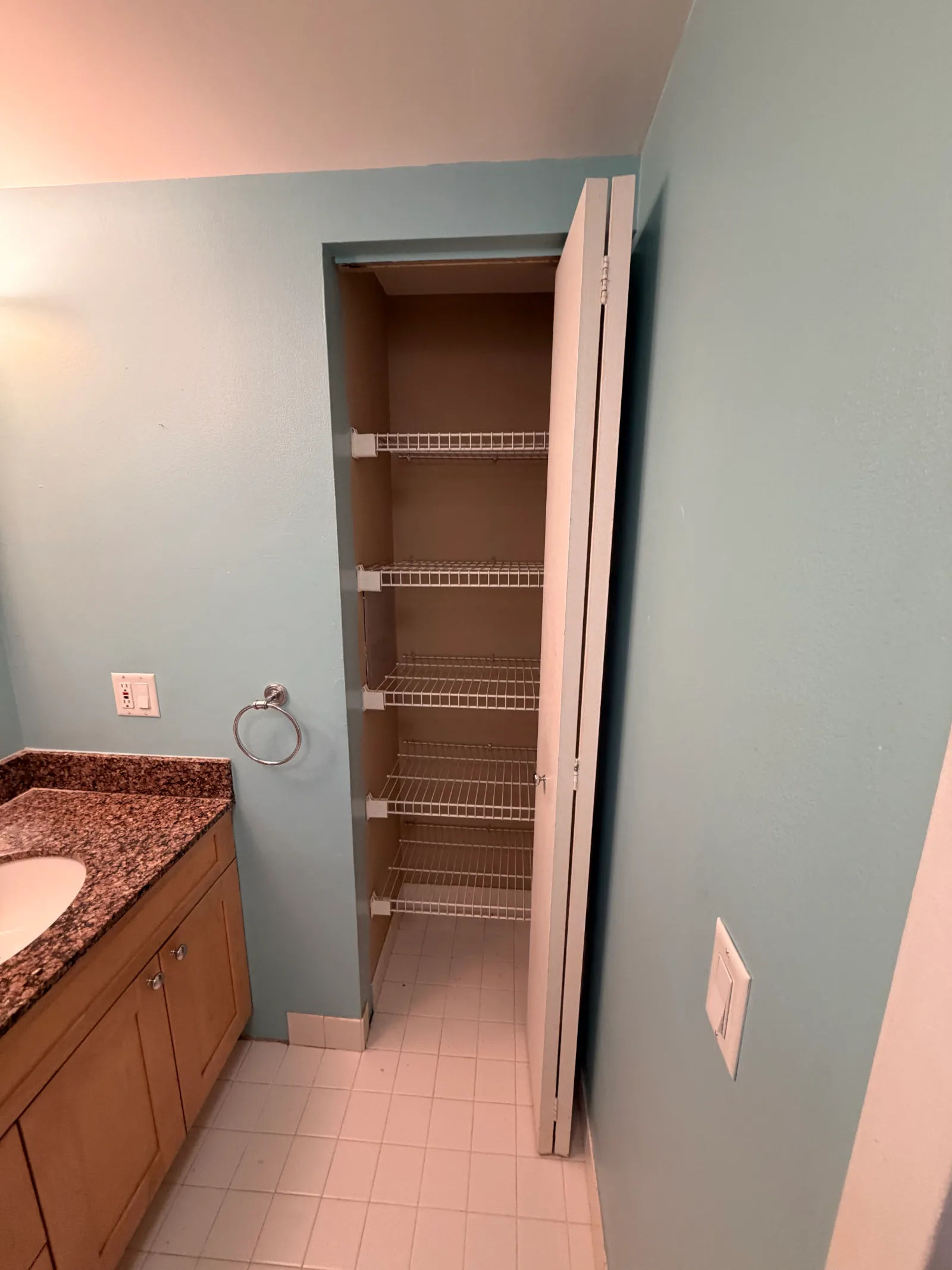 Before -- original white 4x4 ceramic floor tile and two-piece toilet at 124 W Polk, Unit 707, The Lex, Printers Row, prior to renovation