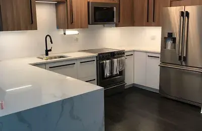 Stunning two-tone kitchen design in Lakeview with architectural ceiling niche and stone countertops