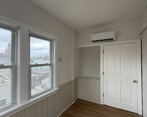 Enclosed sunroom with beadboard wainscoting in Logan Square multi-flat renovation