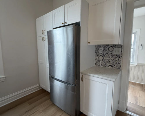 White shaker kitchen with floor-to-ceiling pantry in renovated Logan Square three-flat unit