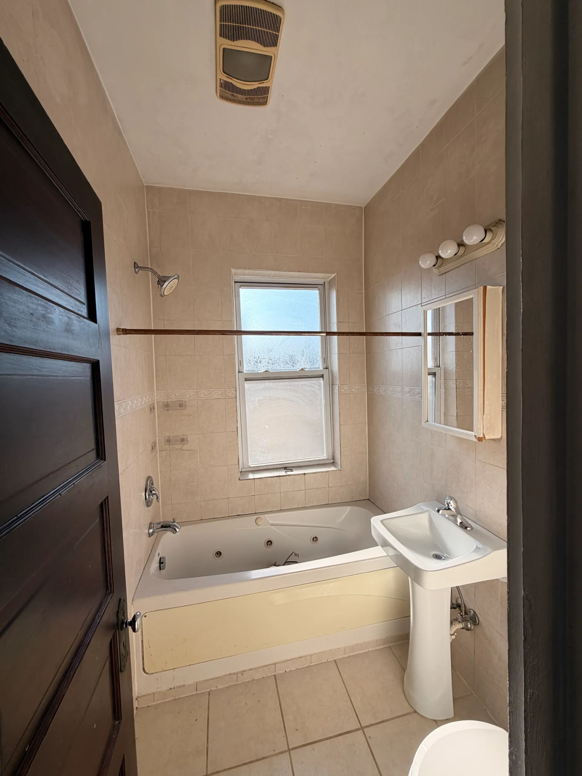 Before photo of original bathtub and dated bathroom in Logan Square Chicago three-flat prior to walk-in shower conversion by Assembly Squad