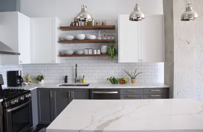 West Loop condo kitchen renovation with two-tone cabinets and floating shelves