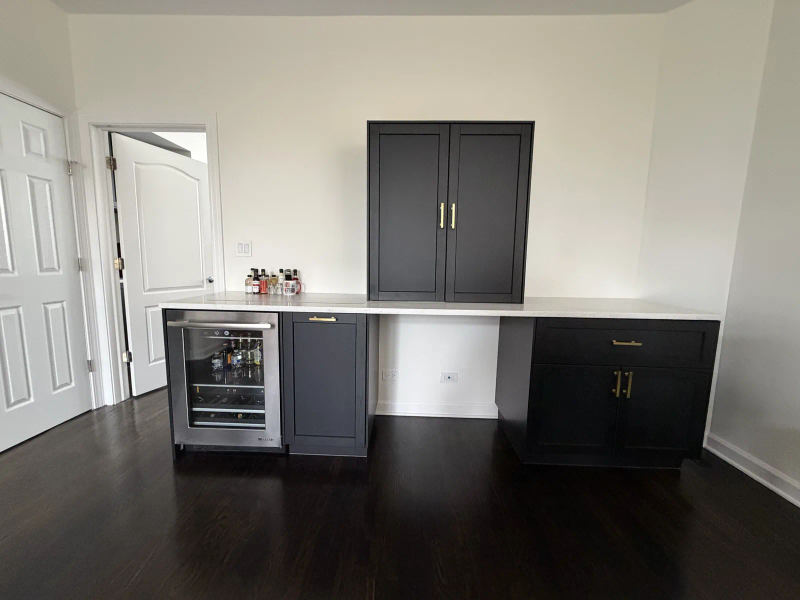 After -- black and brass dry bar with quartz counter, drawer fridge and closed desk-concealment tower