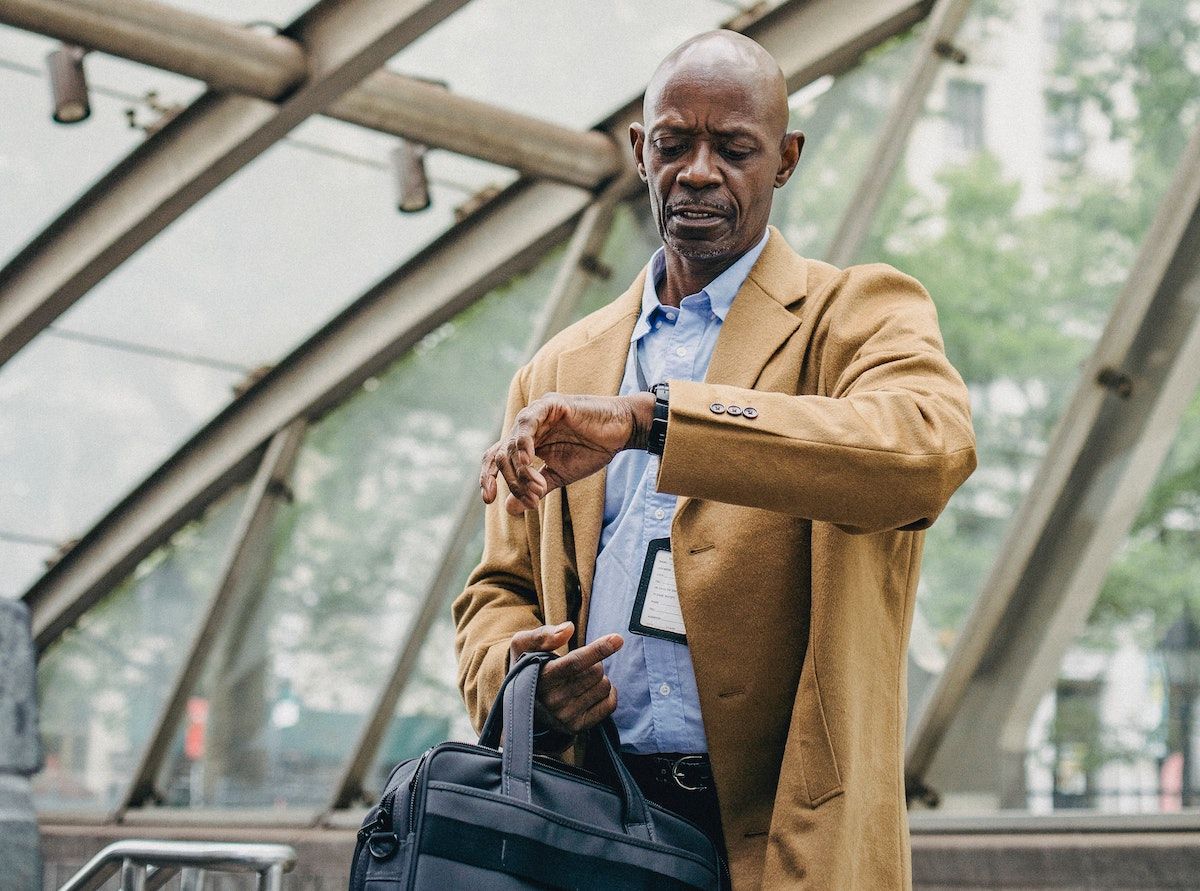 Man checking his watch after his flight delay