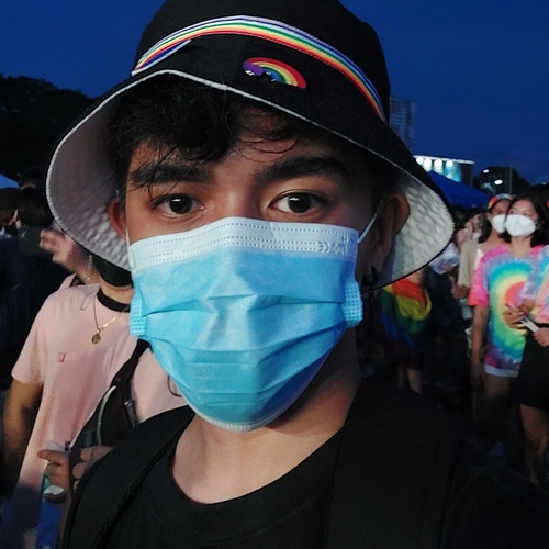 Person wearing a mask and rainbow pin