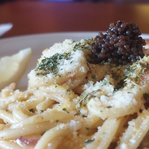 A plate of pasta topped with caviar