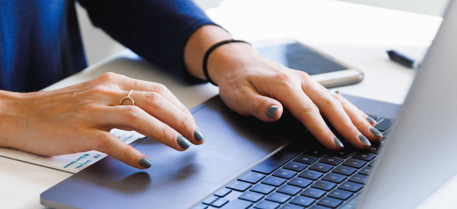 A person typing on a laptop keyboard.