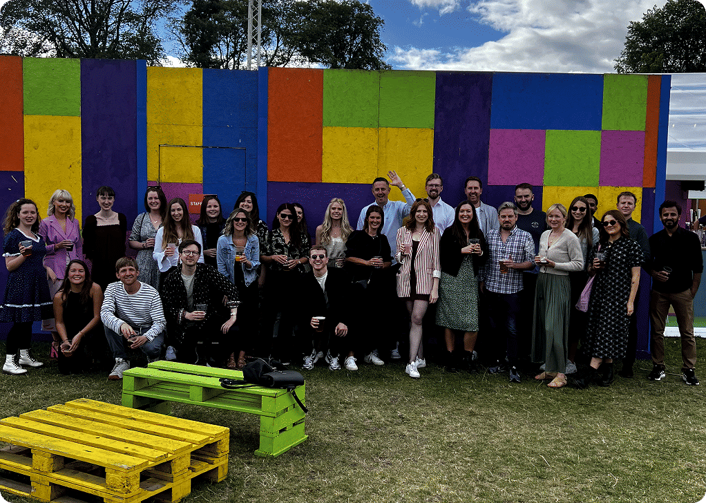 Team 8MS pose in front of a colourful wall.
