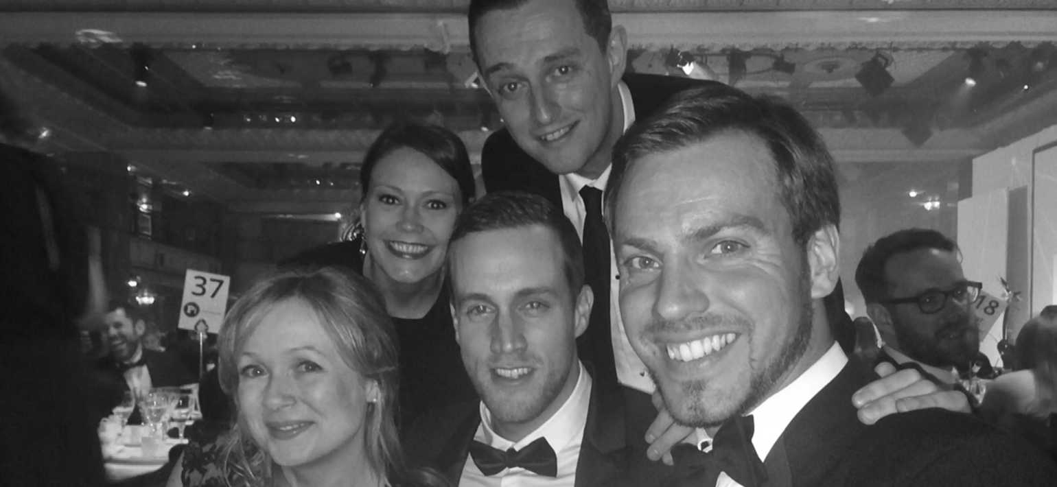 A black and white photo of 8 Million Stories team members at an awards event.